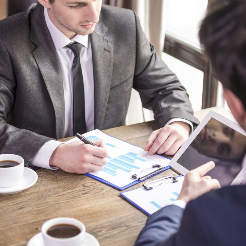 Two businessmen working during a business lunch.